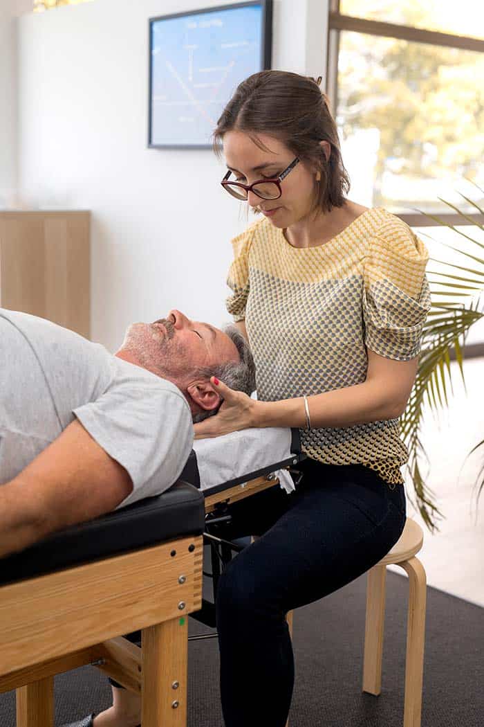 Senior man having physiotherapist look at neck injury