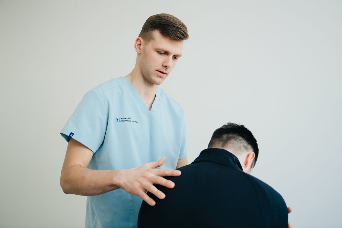 Practitioner assessing a seated patient in a clinic