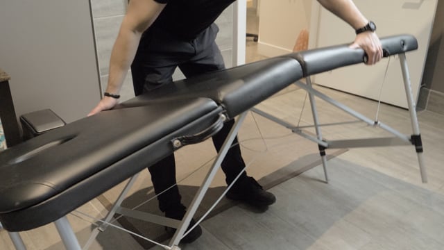 A man using a massage table in a room located in North Vancouver.