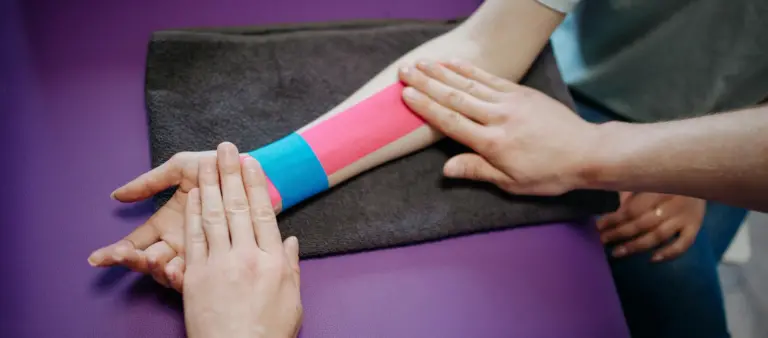 Application of kinesiology tape to a wrist by a therapist in North Vancouver.