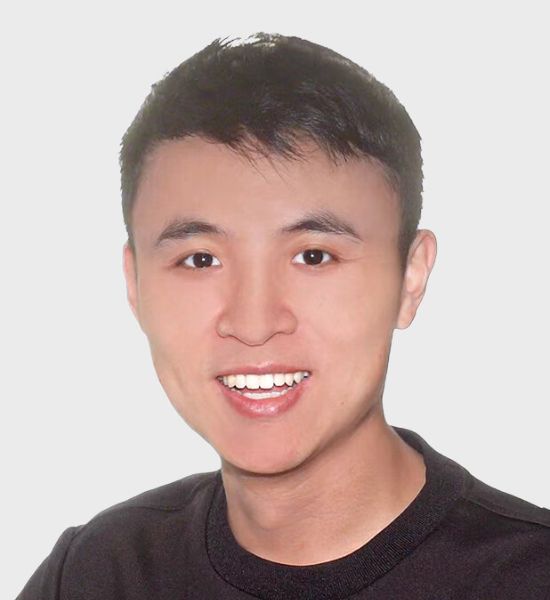 A young man with short black hair smiling against a plain white background. He is wearing a black t-shirt and is one of our dedicated team members.