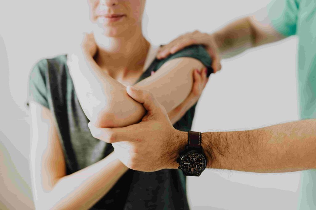 A person receives physical therapy as a therapist supports and stretches their arm and shoulder, similar to What Happens During an Initial Physiotherapy Assessment in North Vancouver.