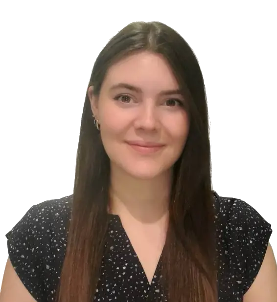 A woman with long straight brown hair, wearing a black and white patterned blouse, is smiling at the camera against a plain light background, embodying the approachable professionalism often seen in a chiropractor.